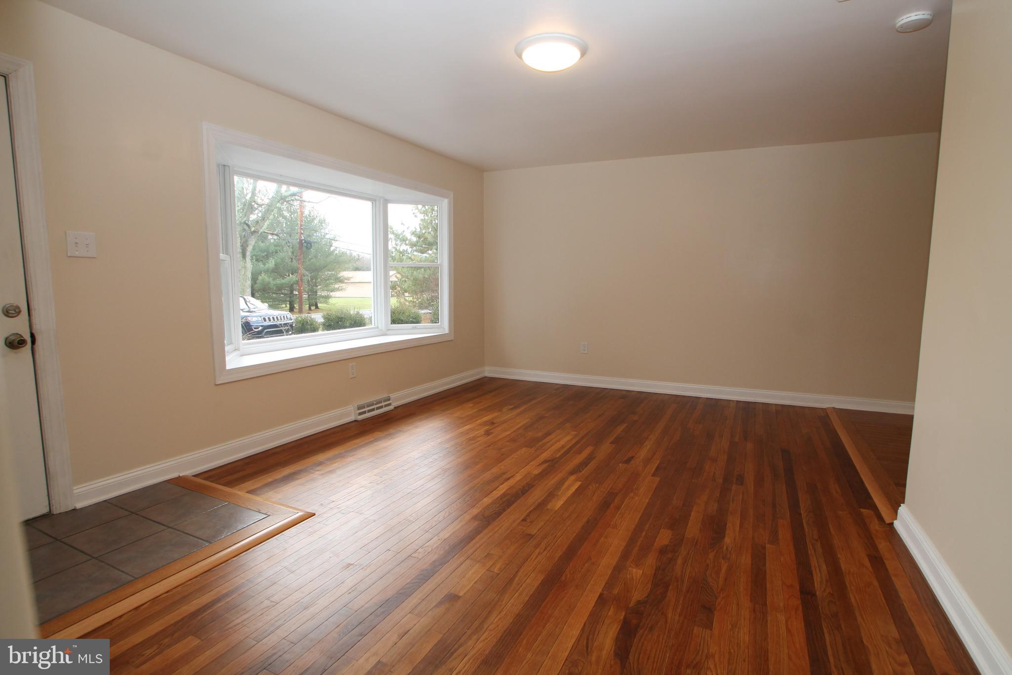 5871 Stump Road Pipersville, PA 18947 - Photo 7 of 33 a view of an empty room with wooden floor and a window