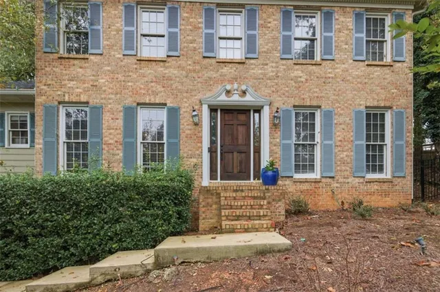 front view of a brick house with a yard