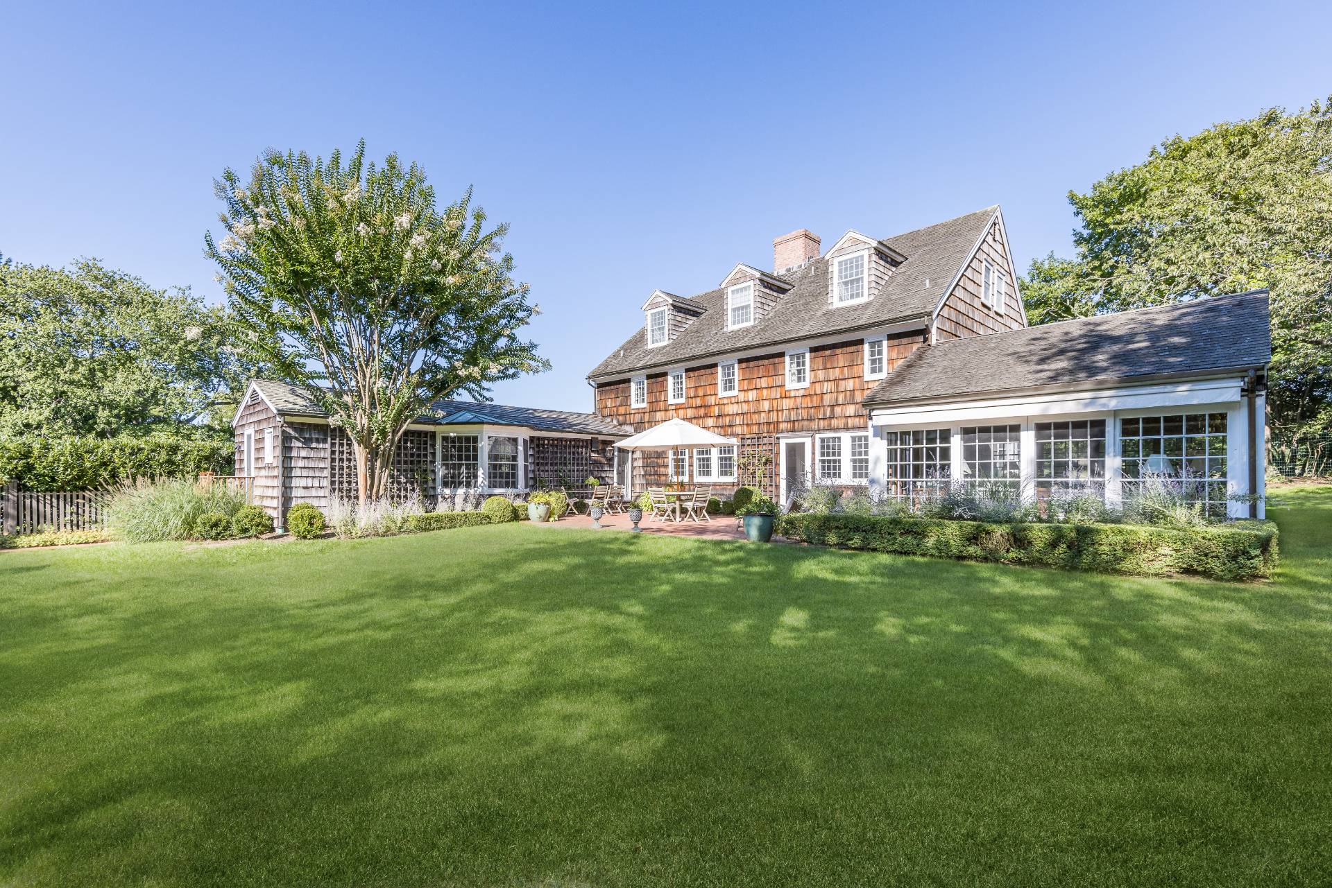 117 Egypt Lane East Hampton, NY 11937 - Photo 5 of 36 a front view of a house with a garden