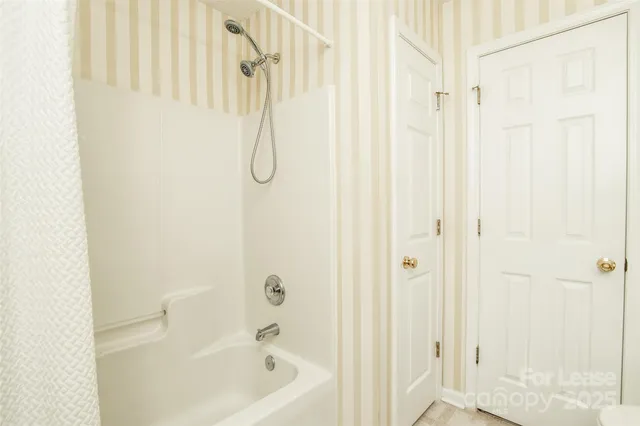 a bathroom with a shower curtain and a shower