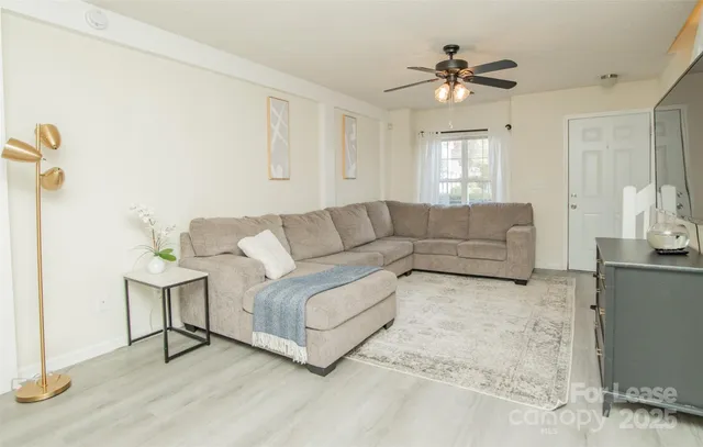 a living room with furniture and a chandelier