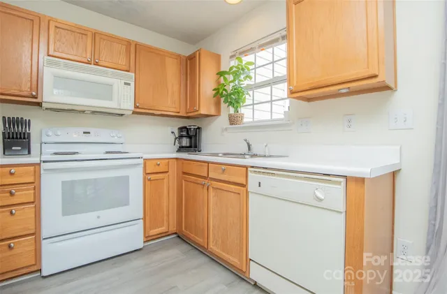 a kitchen with stainless steel appliances granite countertop white cabinets sink and a granite counter top