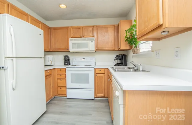 a kitchen with a sink a stove a refrigerator and cabinets
