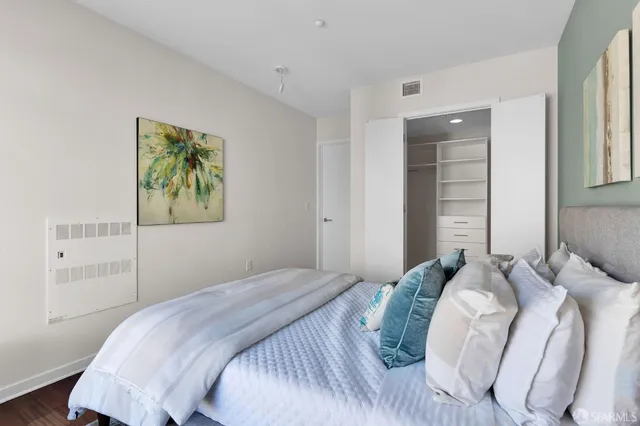 a bedroom with a bed and a painting on the wall