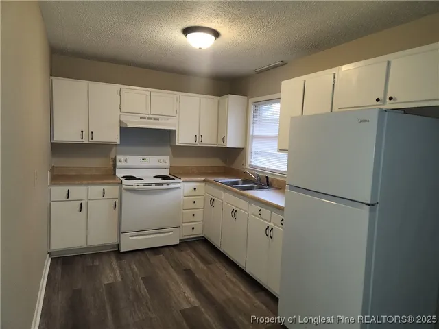 a kitchen with cabinets appliances and a refrigerator