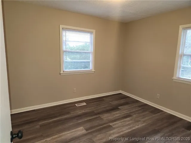 a view of a room with wooden floor and windows in it