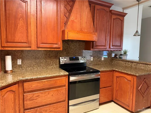 a kitchen with granite countertop wooden cabinets stainless steel appliances and a sink