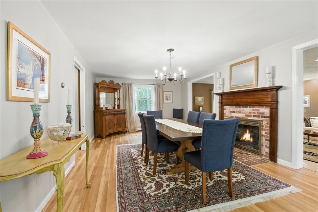 61 Pond Street Boxford, MA 01921 - Photo 19 of 38 a living room with furniture a fireplace and a dining table with wooden floor