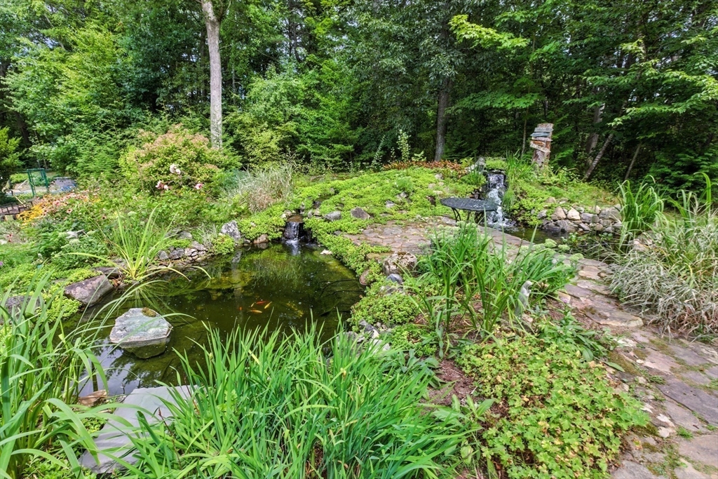 61 Pond Street Boxford, MA 01921 - Photo 36 of 38 a backyard of a house with lots of green space and trees all around