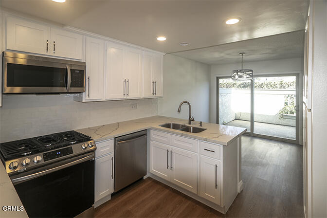 3224 Sunset Lane Oxnard, CA 93035 - Photo 5 of 20 a kitchen with stainless steel appliances granite countertop a stove a sink and a microwave