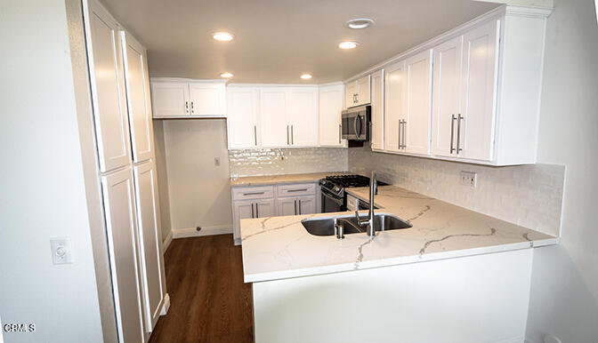 3224 Sunset Lane Oxnard, CA 93035 - Photo 6 of 20 a kitchen with kitchen island a counter top space a sink a refrigerator and cabinets