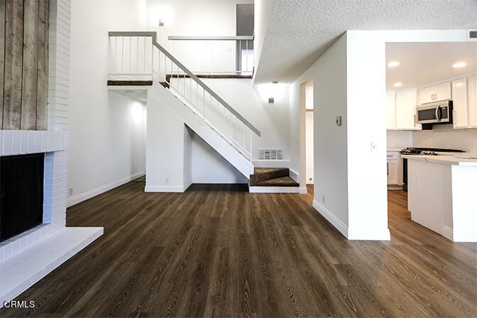 3224 Sunset Lane Oxnard, CA 93035 - Photo 7 of 20 a view of a hallway with wooden floor and staircase