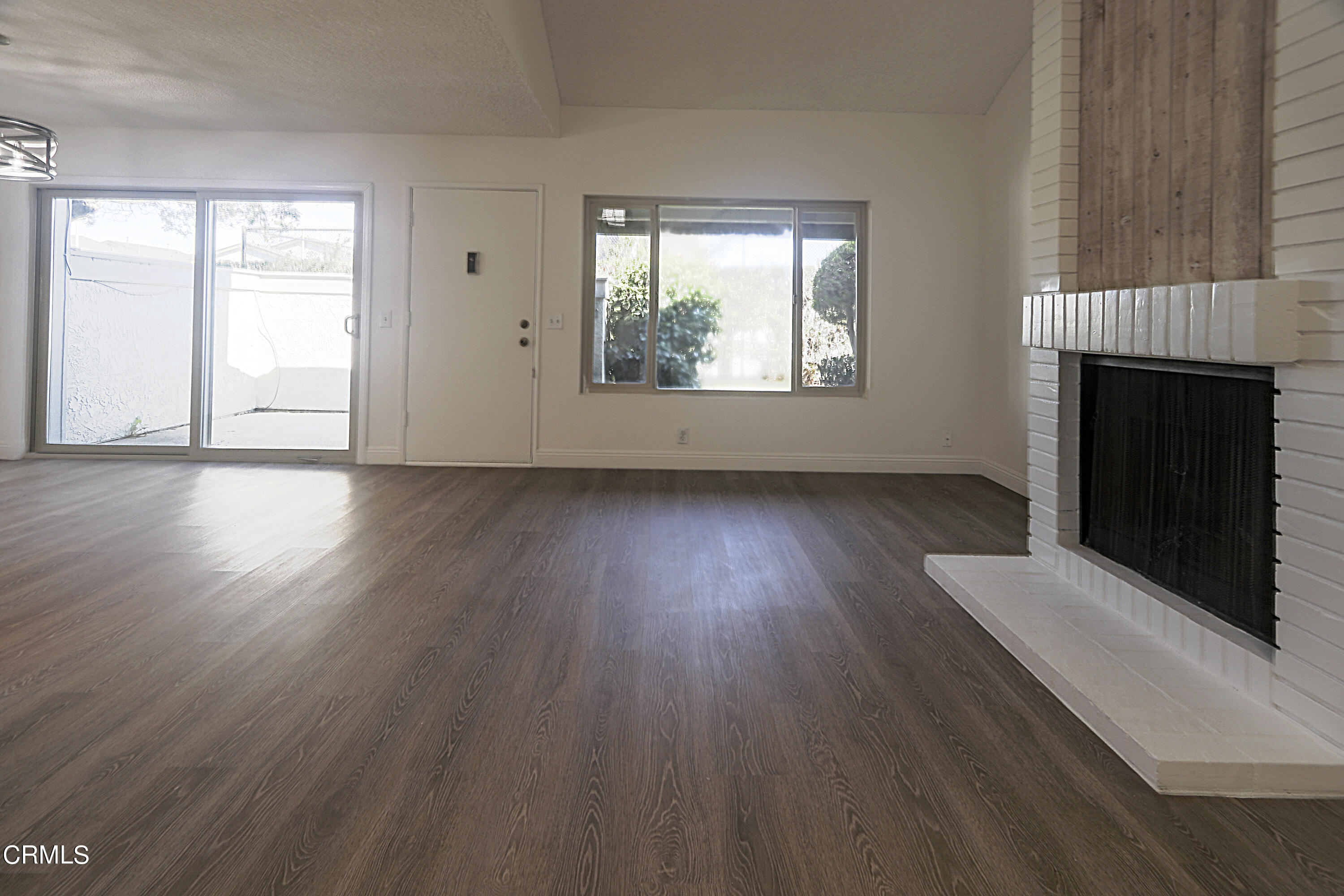 3224 Sunset Lane Oxnard, CA 93035 - Photo 8 of 20 an empty room with wooden floor fireplace and windows