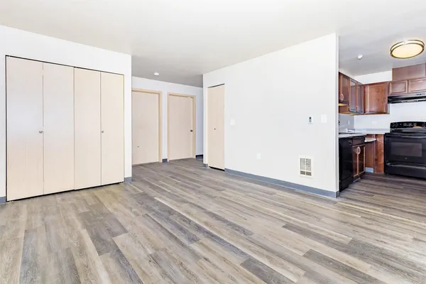 a view of a kitchen with wooden floor and stainless steel appliances