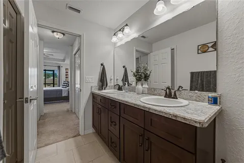 a en suite bathroom with a granite countertop sink and a mirror