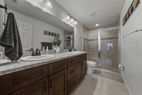 a bathroom with a granite countertop sink a mirror a shower and a bathtub