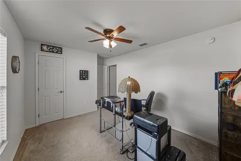 a view of a workspace with furniture and a window
