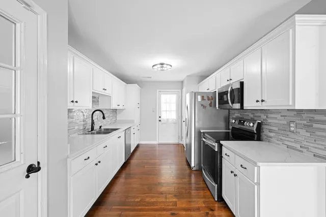 a kitchen with stainless steel appliances a sink stove and refrigerator