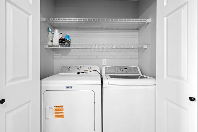 an empty room with chandelier fan and windows