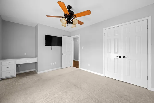a view of an empty room and a chandelier fan