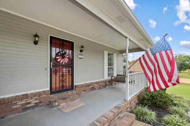 a view of an empty room with wooden floor fireplace and a window