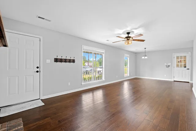 wooden floor fireplace and windows in an empty room