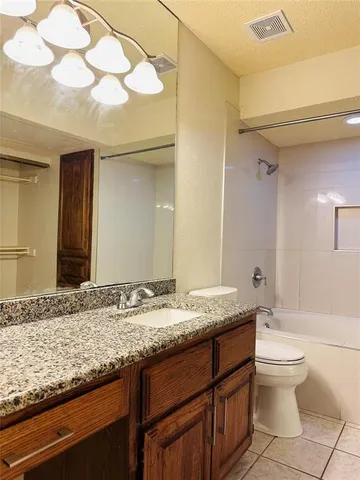 a bathroom with a granite countertop sink a toilet and a mirror