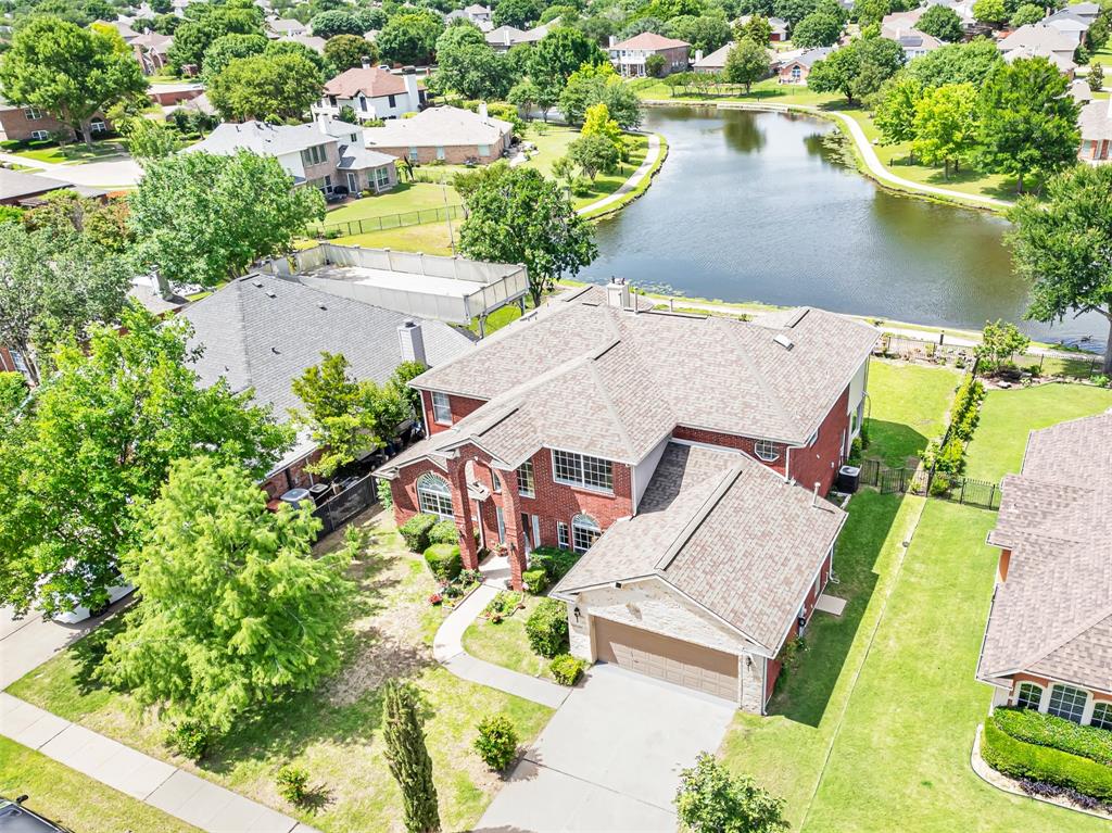 an aerial view of a house with a garden and lake view