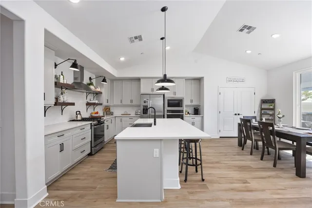 a large kitchen with kitchen island a sink table and chairs