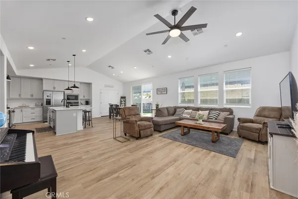 a living room with furniture kitchen view and a large window