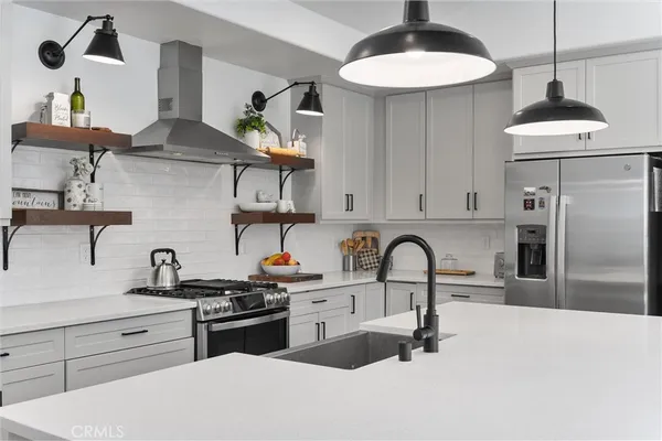 a kitchen with stainless steel appliances a sink a stove and refrigerator