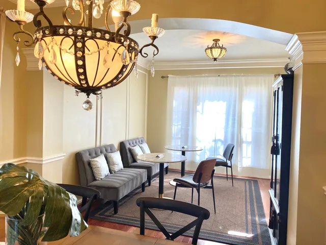 a view of a dining room with furniture and a chandelier