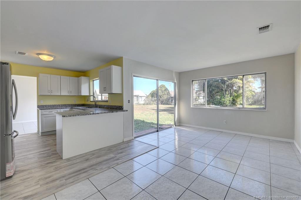 297 Southwest Homeland Road Port St. Lucie, FL 34953 - Photo 13 of 32 a kitchen with stainless steel appliances granite countertop a refrigerator and a stove top oven