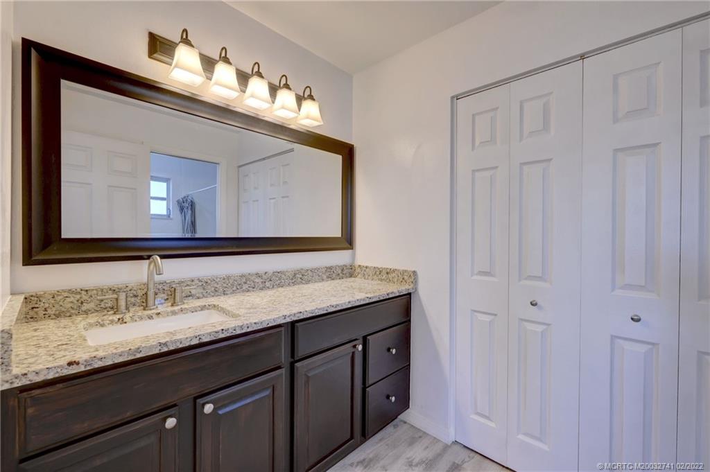 297 Southwest Homeland Road Port St. Lucie, FL 34953 - Photo 21 of 32 a bathroom with a double vanity sink and a mirror