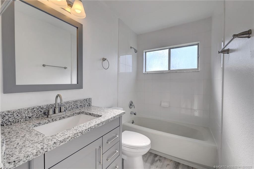 297 Southwest Homeland Road Port St. Lucie, FL 34953 - Photo 23 of 32 a bathroom with a granite countertop sink toilet and shower