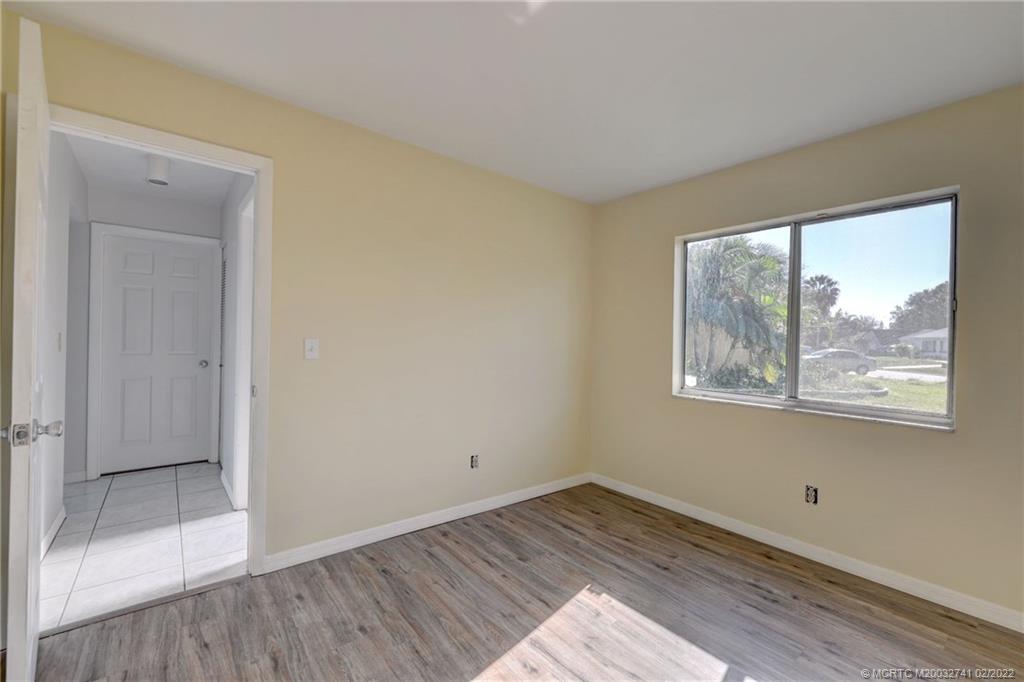 297 Southwest Homeland Road Port St. Lucie, FL 34953 - Photo 26 of 32 a view of empty room with wooden floor and fan