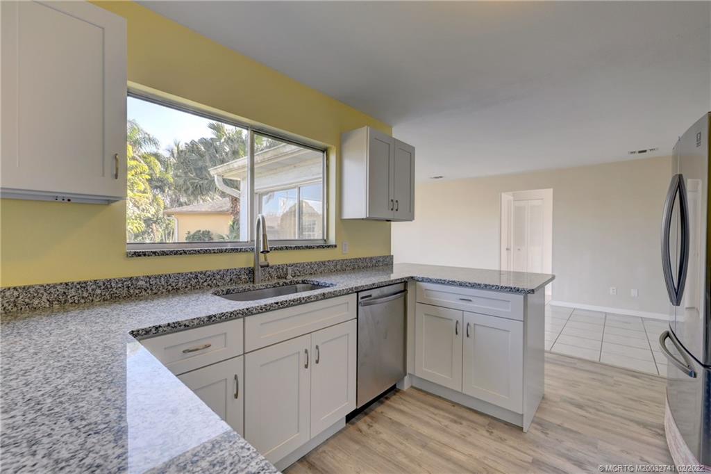 297 Southwest Homeland Road Port St. Lucie, FL 34953 - Photo 10 of 32 a kitchen with a sink cabinets and window