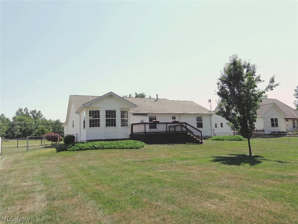 Rear view of the house showing the hex shaped dining room, deck, and lots of green space to roam! Also as a FYI...Theres Gutter guards installed on all the gutters, theres motion sensor exterior lights and a home security system just to name a few of the many features this home offers.