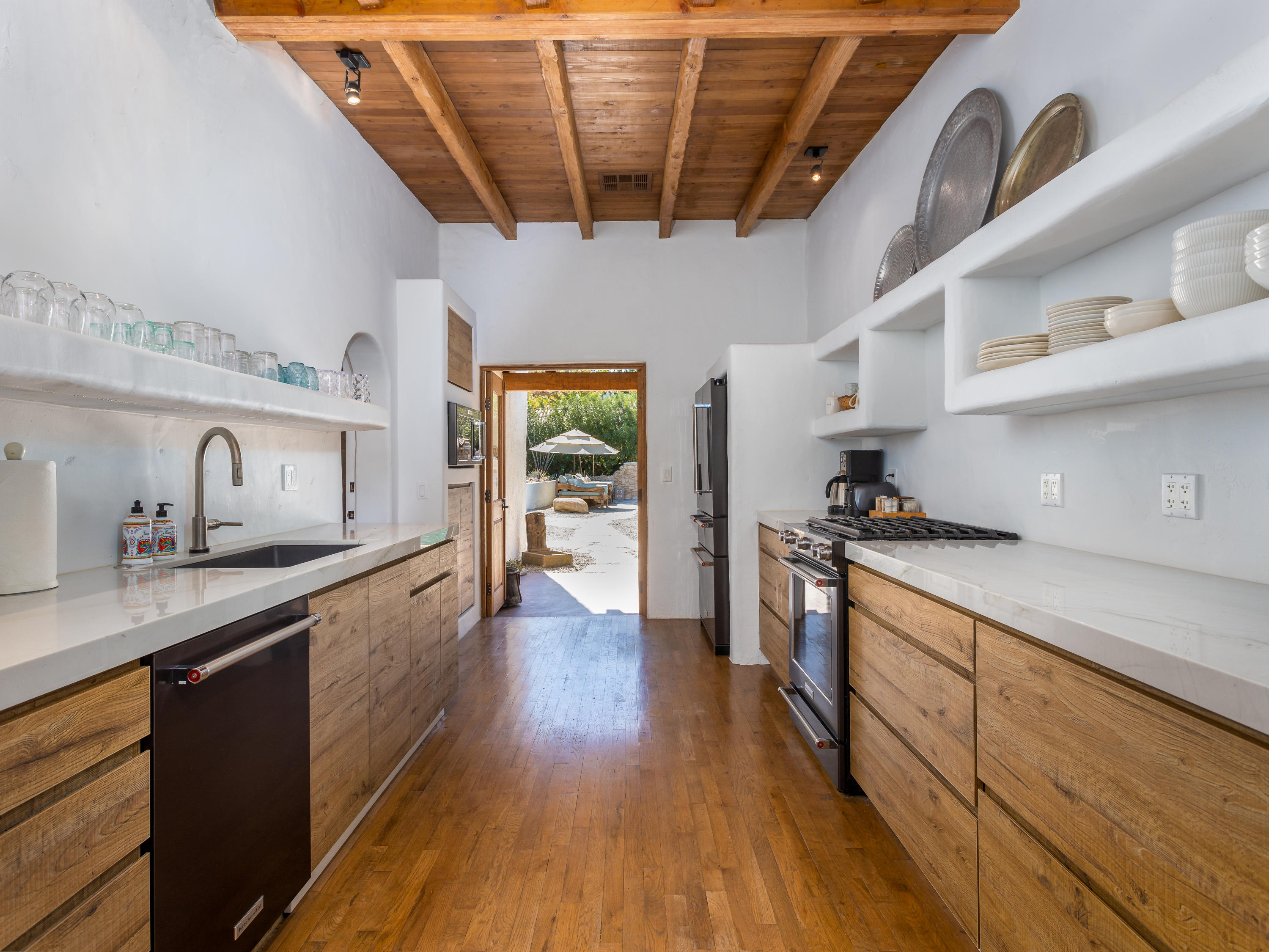 71607 Sahara Road Rancho Mirage, CA 92270 - Photo 15 of 40 a kitchen with stainless steel appliances granite countertop a sink a stove and wooden floors