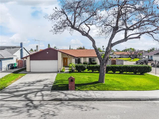 a view of a house with a yard and large trees