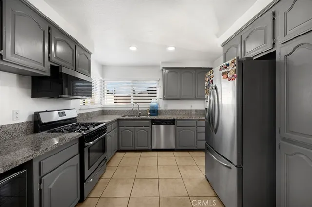a kitchen with stainless steel appliances granite countertop a refrigerator stove a sink and dishwasher
