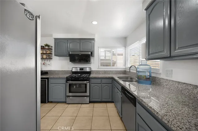 a kitchen with stainless steel appliances granite countertop a sink stove oven and refrigerator