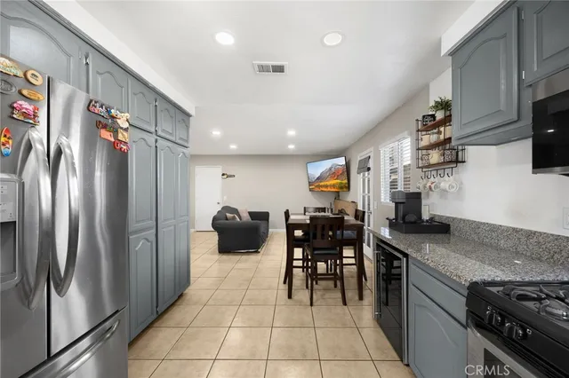 a kitchen with stainless steel appliances granite countertop a refrigerator a stove and a sink