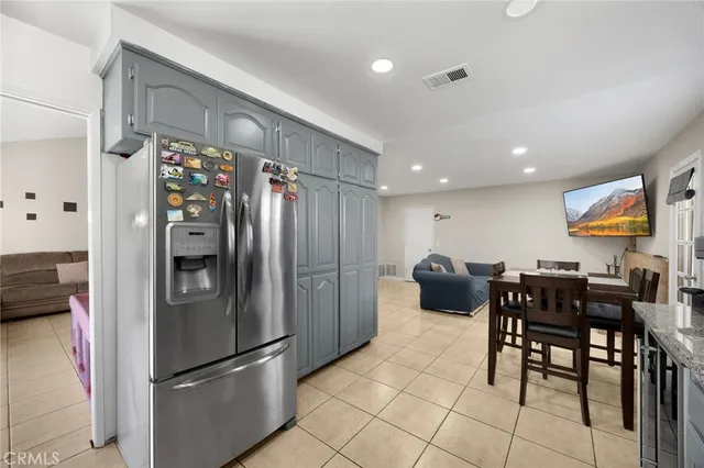 a kitchen with stainless steel appliances granite countertop a refrigerator and a dining table