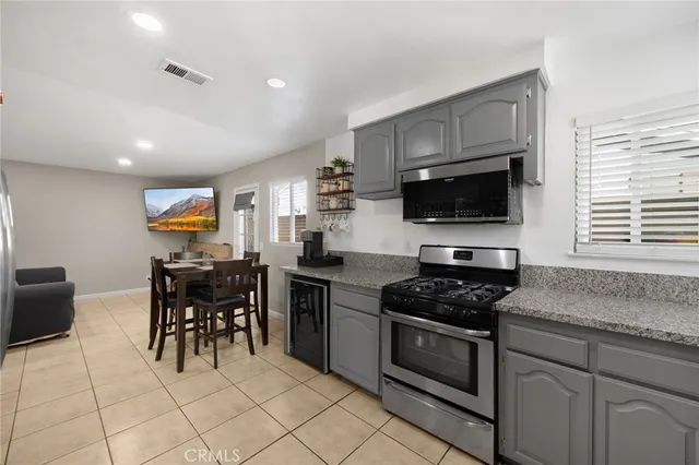 a kitchen with granite countertop a sink cabinets and stainless steel appliances