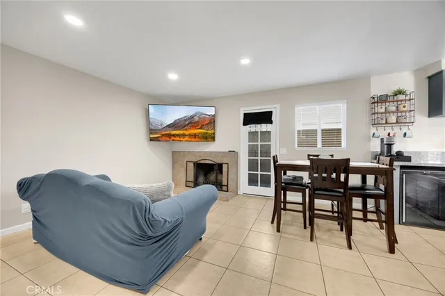 a living room with furniture a fireplace and a open kitchen view