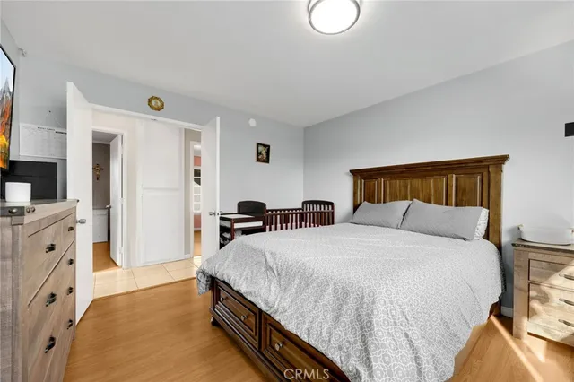 a spacious bedroom with a bed and a flat screen tv