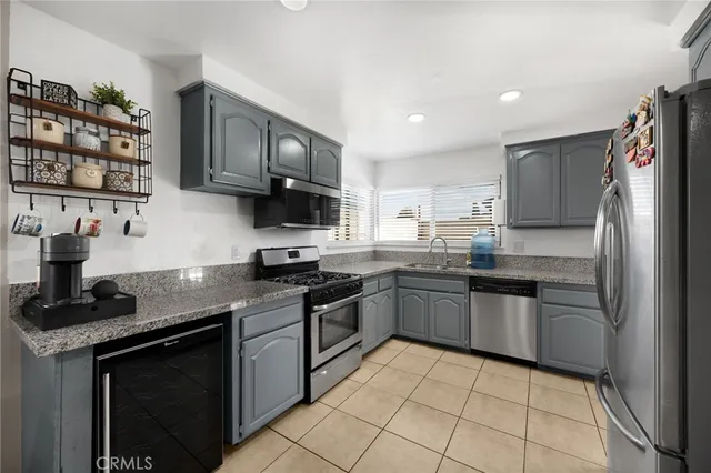 a kitchen with stainless steel appliances granite countertop a stove sink and cabinets