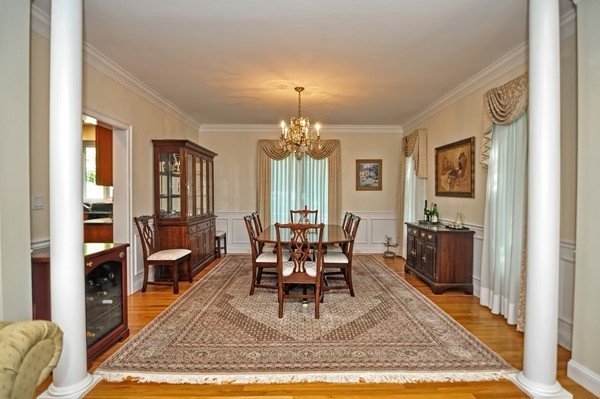316 Hartman Road Newton, MA 02459 - Photo 16 of 30 a dining room with wooden floor a chandelier a wooden table and chairs