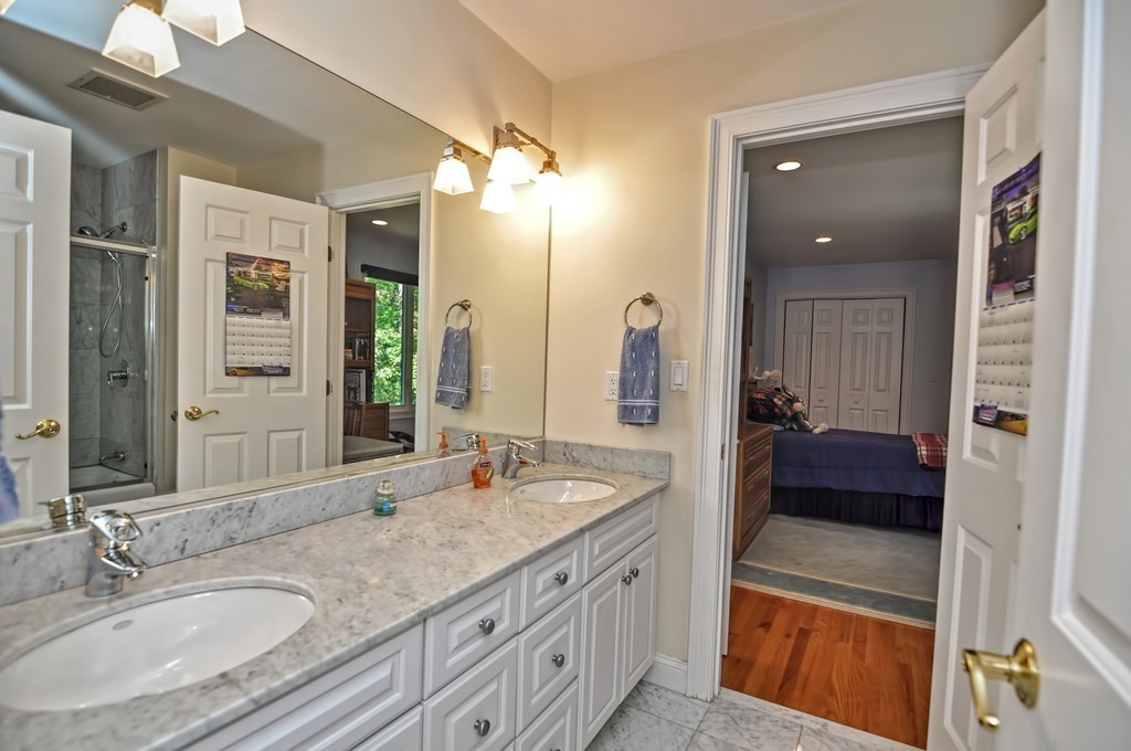 316 Hartman Road Newton, MA 02459 - Photo 22 of 30 a bathroom with a granite countertop double vanity sink a mirror and a shower